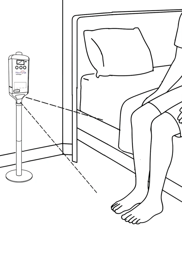 A patient seated near a scanner that detects movement within a three-metre radius.